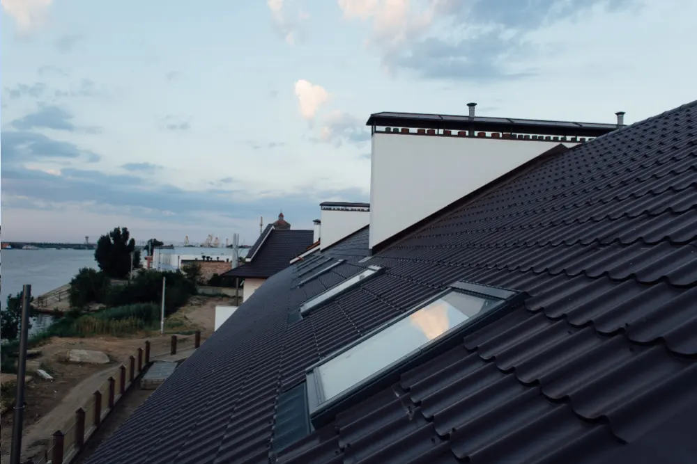Having a new roof fitted is a major project and a little preparation goes a long way. While our roofing team will handle everything to do with the work itself, there are a number of practical steps you can take beforehand to help the job run smoothly, protect your belongings and reduce disruption to your daily routine. Whether it’s a pitched roof replacement or a flat roof being overhauled on a rear extension, the same principles apply. This guide covers everything you need to know before the team arrives. If you haven’t yet confirmed your booking and would like a free written quotation before you start planning, contact Essex Roofing today for a no-obligation assessment. Get a free quote What Should You Do Before the Scaffolding Goes Up? The first physical sign that your roof installation is beginning is usually the arrival of the scaffolding team. Before they arrive, there are a few things worth sorting out around the exterior of your property. Start by clearing the area directly around the base of your home. Move garden furniture, plant pots, ornaments and any outdoor equipment away from the walls and perimeter. If you have a vehicle parked close to the house, it’s worth moving it to a safe distance to avoid any risk of dust or debris landing on it during the strip-out stage. Letting your immediate neighbours know that scaffolding is going up is also a considerate step, particularly if access to a shared driveway or path may be briefly affected. Estimate Your Roof Charges What Type of Roof Do You Have? Please select the roof type of your property. This helps us determine the best installation method and equipment for your home. Flat Roof Flat Roof Pitched Roof Pitched Roof Conservatory Roof Conservatory Roof It just takes 60 Sec And then you can book a free consultation Get a clear cost breakdown Find out how much you’ll save Get a clear quote Protecting the Interior of Your Home Many homeowners don’t realise that a roof installation can create mild vibration and movement throughout the property, particularly during the stripping stage. While this is entirely normal, it’s worth taking a few precautions inside your home. Remove or secure any fragile items from loft storage, as movement on the roof can dislodge things that aren’t properly packed away. Pictures and mirrors hanging on internal walls near the roofline are worth taking down temporarily as a precaution. If you have a loft conversion, speak to your roofing team beforehand so they’re aware of the layout and can take extra care in that area. Area of the Home What to Do Before Installation Garden and driveway Clear furniture, equipment and vehicles from the perimeter Loft space Remove fragile or unsecured items from storage Internal walls Take down pictures or mirrors close to the roofline Pets Keep pets calm and away from the work area Neighbours Give advance notice of the work and likely duration Vehicles Park away from the property during active work days Outdoor plants Move pots and planters away from the scaffold base Get a free quote How to Prepare Your Loft for a Roof Installation If your roofer needs access to the loft at any point during the project, whether for a structural inspection or to check for signs of moisture, it’s helpful to have the space reasonably accessible before work begins. Clear a path from the hatch to the main roof area if possible and ensure any lighting in the loft is working. It’s also sensible to check the loft yourself before the project starts. Note the condition of the insulation, look for any existing signs of damp or daylight and take a few photographs. Having a baseline record before work begins means you have something to refer back to should any questions arise once the roof installation is complete. What to Expect on Installation Day On the first full day of work, the team will typically begin stripping the existing roof covering once scaffolding is confirmed as secure. This can be the noisiest part of the whole project, so it’s worth being prepared for some disruption during the morning in particular. Your roofing team should let you know roughly what to expect each day as the project progresses. A good team will keep you updated on what they’ve found during the strip, particularly if any structural issues come to light that need to be discussed before the new roof is fitted. Being available to speak to the team during the working day, even briefly, makes communication much easier and helps avoid delays. Learn More Managing Dust and Debris Roofing work, like most construction activity, generates dust and debris. While your team will work to contain this as much as possible, there are steps you can take inside your home to minimise any impact. If your loft hatch isn’t well sealed, placing a draught excluder or rolled-up towel against it during active work days can help prevent fine dust from filtering through. Covering any loft storage boxes or items you can’t move with dust sheets is also worthwhile. Outdoors, a reputable roofing team will use protective sheeting or a waste skip to manage the old roofing materials responsibly rather than leaving debris to build up around your property.